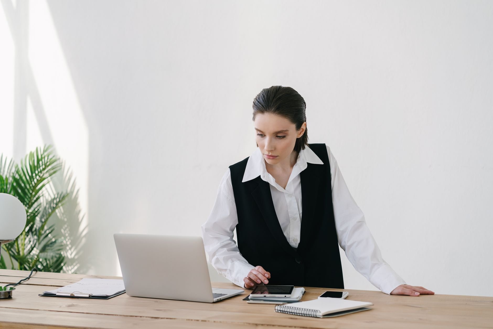 Professional woman using technology and laptop at her desk. Modern office workspace.